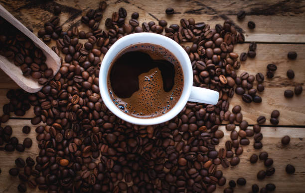 istock Black coffee in white cup, with coffee beans on wooden background 1132263646