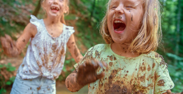 Girls playing in mud stock photo