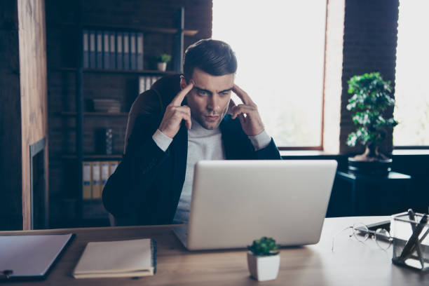 istock Portrait of his he stylish trendy handsome guy specialist exhausted after difficult task touching temples reading financial report industrial loft interior workplace workspace 1132264133