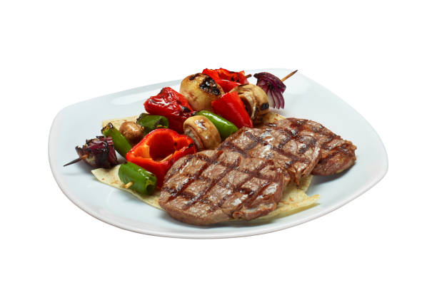 filetes de ternera aislados con brochetas de verduras en una placa blanca - fillet meat portion fillet steak fotografías e imágenes de stock