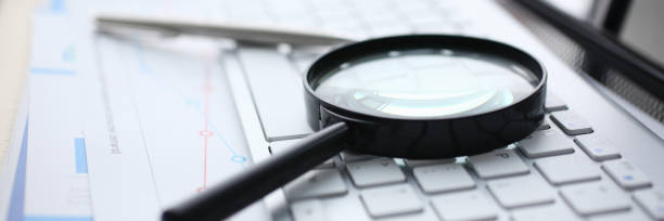 Magnifying glass lies on white keyboard on