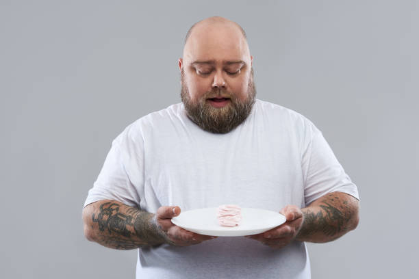 istock Calm fat man looking at the marshmallow souffle on the plate 1132265876