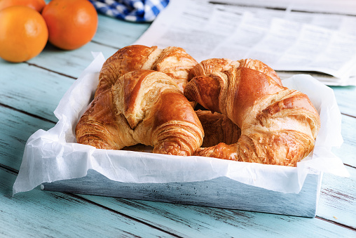 Croissant for breakfast on wooden surface