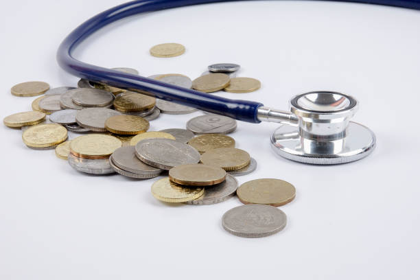 istock Close-Up Of Coins With Stethoscope Over White Background 1132269451