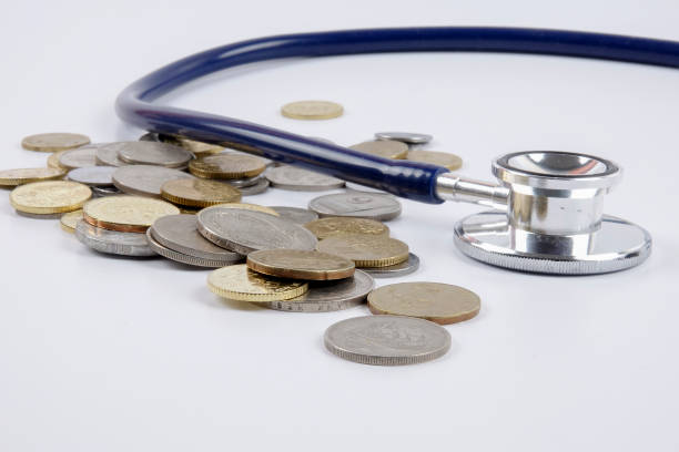 istock Close-Up Of Coins With Stethoscope Over White Background 1132269501