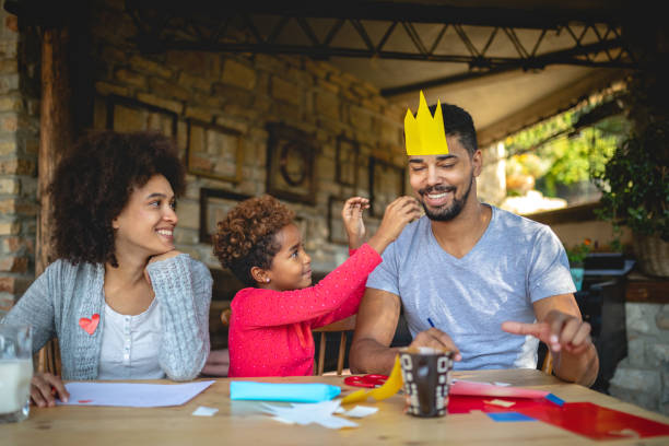 istock Playful daughter making a paper crown for her father 1132271172
