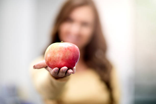 istock Young woman holding a red apple 1132271233