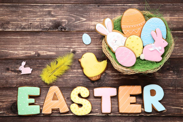istock Easter gingerbread cookies in basket with feather on brown wooden table 1132272294