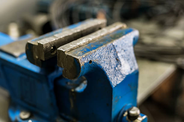 istock Blue old vise mounted on a workbench in a workshop or carpentry shop. Device for clamping and holding objects and parts. 1132274288