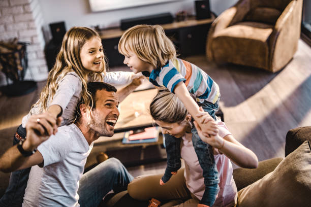 istock Young playful parents having fun with their small kids at home. 1132277606