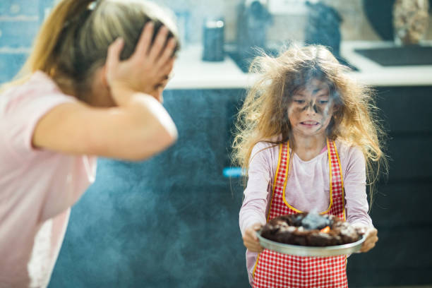 ich denke, der kuchen wurde etwas länger gebacken, als er sollte, mama! - little cakes stock-fotos und bilder