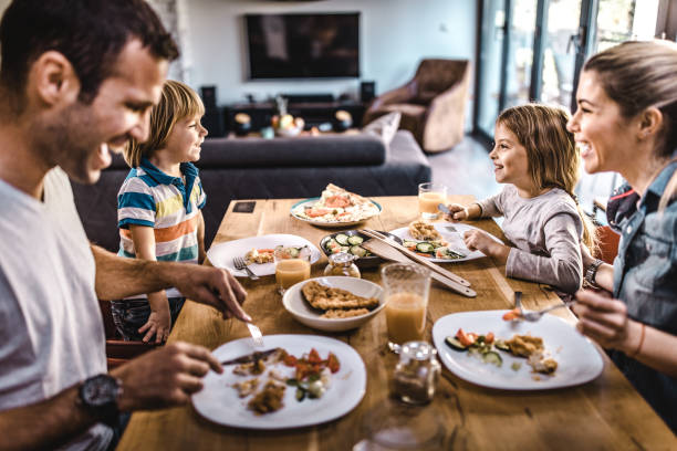 junge glückliche familie spricht beim mittagessen am esstisch. - after dinner stock-fotos und bilder