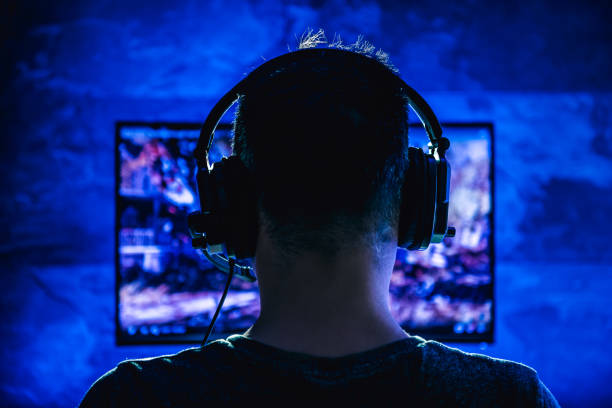 Men playing video games Men wearing headphones playing video games late at night arcade photos stock pictures, royalty-free photos & images