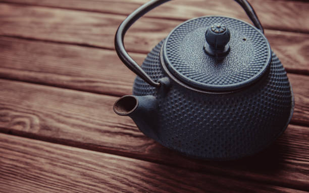 istock Old iron teapot on a wooden table. 1132282596