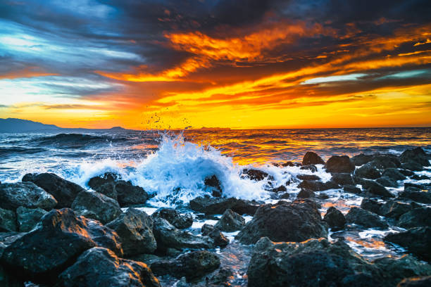 istock Bright sunset under the storm sea with waves splashes 1132282749
