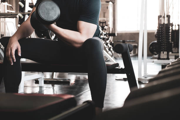 istock Young man exercising building muscles at the gym 1132282860