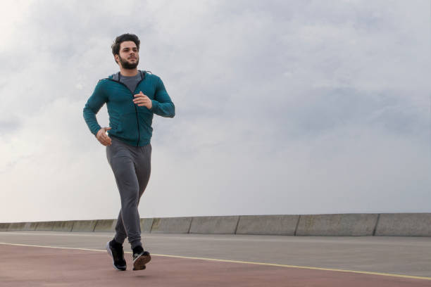 istock Young Man Jogging on A Foggy Winter Day 1132282905