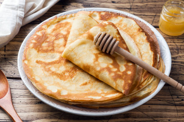 istock Thin pancakes on a plate with honey. Wooden background. 1132283075