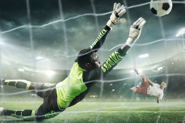 Soccer goalkeeper in action at professional stadium. Professional soccer goalkeeper in action playing at the night stadium. Goalkeeper trying to catch the ball in flight. 3D model of the stadium was created by me (the author) scoring a goal stock pictures, royalty-free photos & images