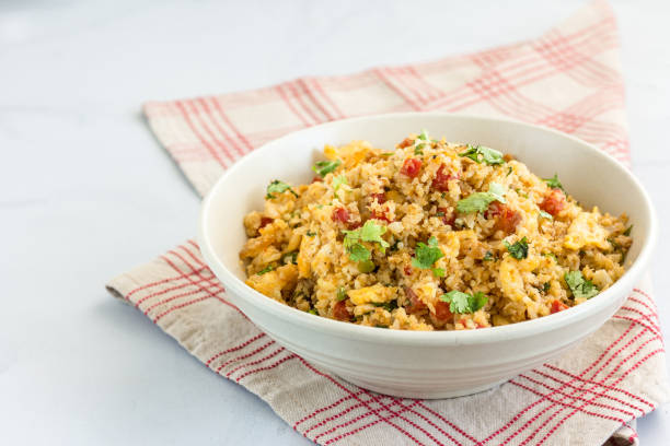 Cauliflower Rice in a Bowl - Low Carb Food Cauliflower Fried Rice in a Bowl on White Background.  Low Carb, Healthy, Stir-Fried One Pot Dish. Healthy Comfort Food Concept. fried rice stock pictures, royalty-free photos & images