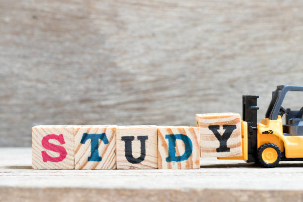 istock Toy forklift hold letter block y to complete word study on wood background 1132290388