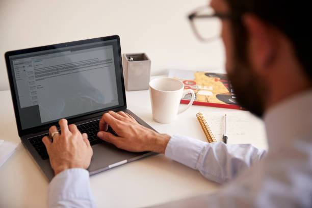 istock Businessman Sitting At Desk Working On Laptop In Modern Office 1132290905