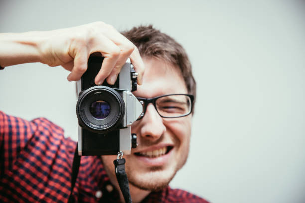 istock Young man is taking a picture with a vintage camera 1132290992