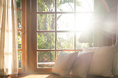 Living room with part of sofa in sunny day and white curtain.