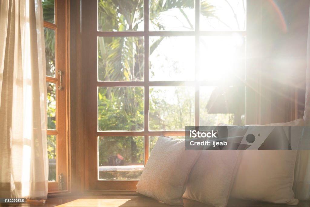 Living room with part of sofa in sunny day and white curtain. Living room with part of sofa in sunny day and white cushion interior background concept. Window Stock Photo