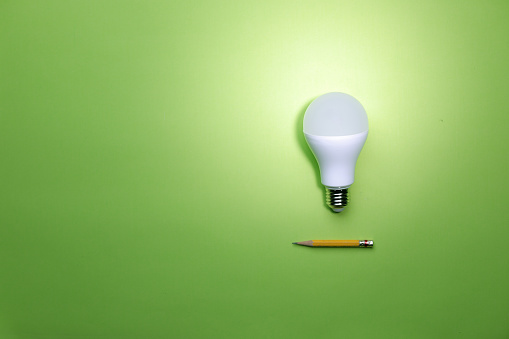 Creativity inspiration ideas concept with lightbulb on green background