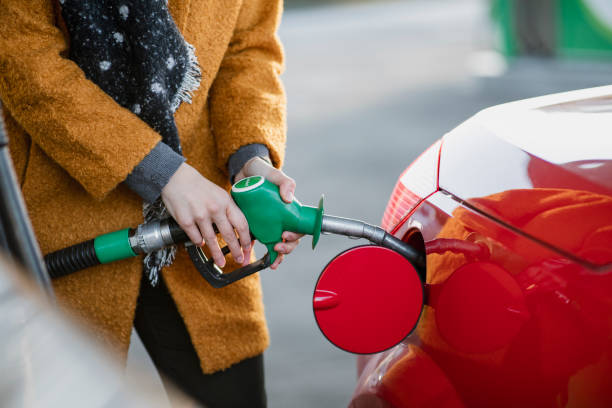 Refuelling Before Work Close up shot of a young businesswoman filling her car with fuel before work. fuel pump photos stock pictures, royalty-free photos & images