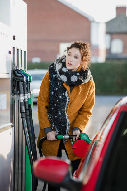 bizneswoman wypełnienie jej samochód - gas station gasoline refueling fuel pump zdjęcia i obrazy z banku zdjęć