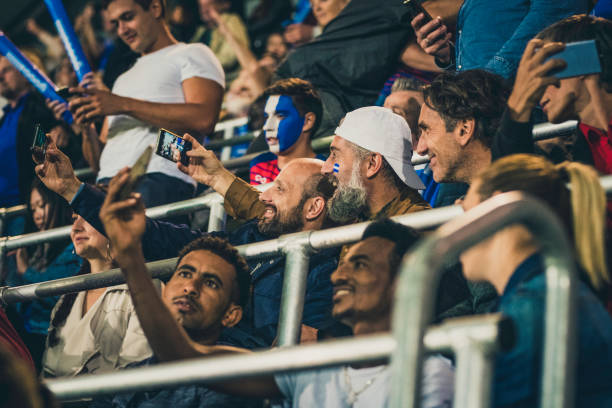 istock Multi ethnic group taking selfies in a football stadium 1132295641