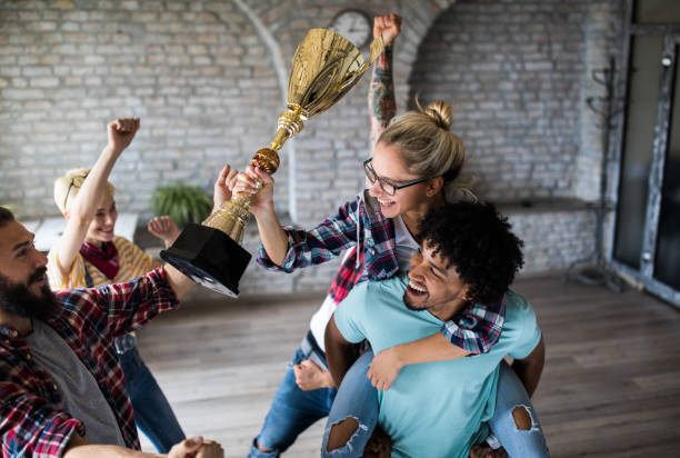 istock Happy freelance team celebrating winning a trophy at casual office. 1132298018