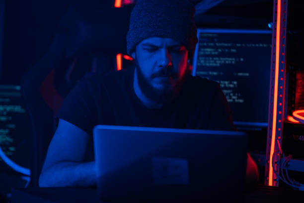 istock Hacking and criminal concept.A hacker in a secret hiding place is neon light 1132300520