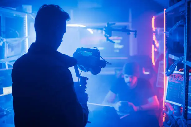 Photo of The process of filming. Cameraman shoots a scene with a hacker.