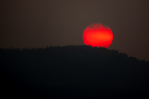Big red sun on hills on sunset view