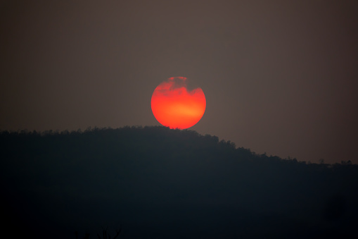 Big red sun on hills on sunset view