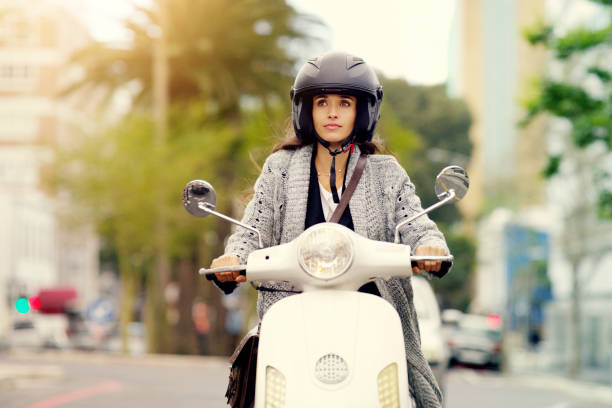 Shot of an attractive young woman riding around the city on her scooter