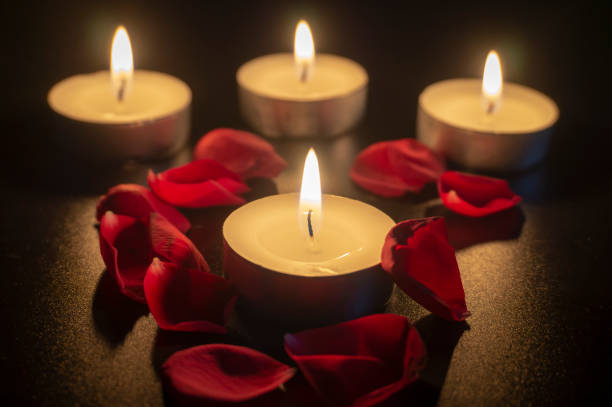 istock Four tea candles and rose petals in the dark 1132307541