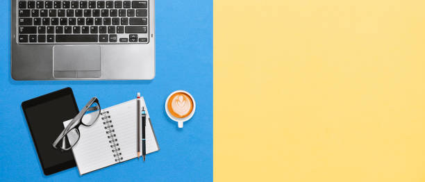 istock Modern office desktop workplace with copy space on bright yellow and blue background 1132308395