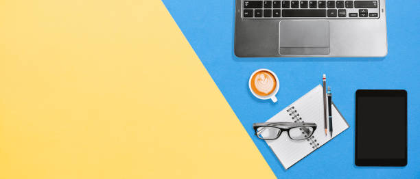 istock High angle view of office colorful office desk with copy space, Laptop, notebook, tablet and coffee 1132308409