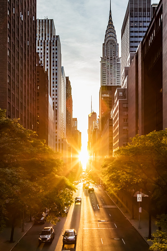 Sunset light shining on the buildings and cars on 42nd Street in Midtown New York City around the time of the Manhattanhenge summer solstice