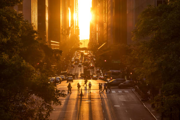 Rays of sunlight shining down on the people and traffic at the intersections along 42nd Street through Midtown Manhattan in New York City