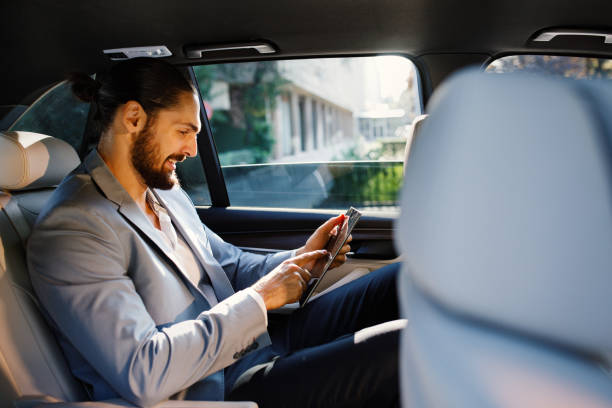 istock Businessman using digital tablet in a taxi 1132310107