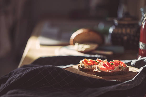 due panini di pane di segale nella tradizione tedesca con paprika rossa e crema di formaggio su una tavola di legno nella cucina soleggiata - cheese loaf foto e immagini stock