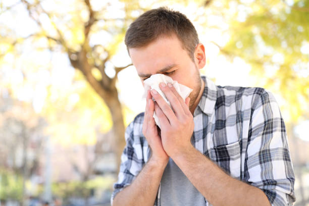 istock Allergic man sneezing covering nose with wipe 1132311969
