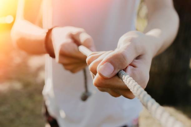 istock closeup of the hands pulling the rope with force 1132312490
