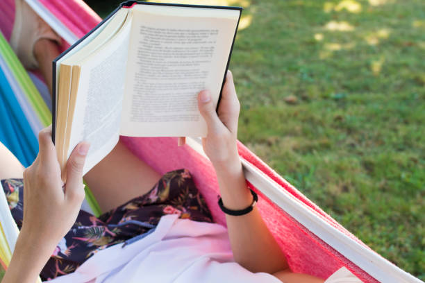 istock hands with the book reading in the hammock 1132312512