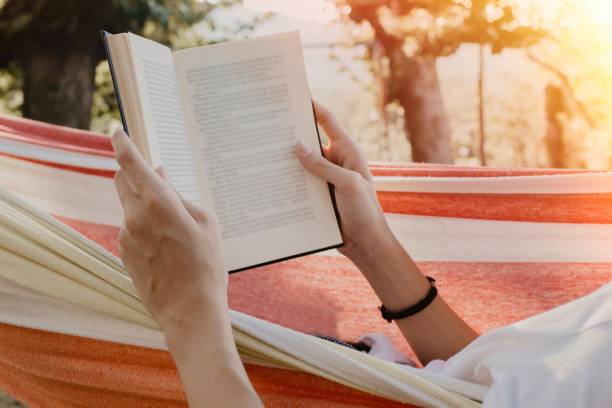 istock hands with the book reading in the hammock 1132312624